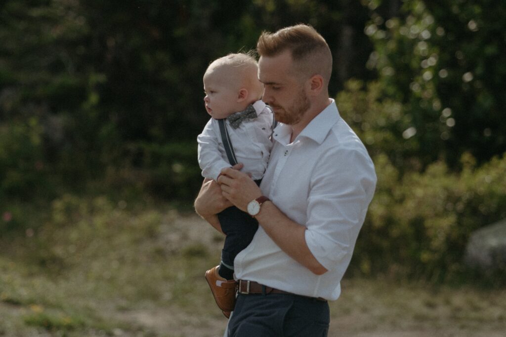 groom carries baby son to wedding ceremony