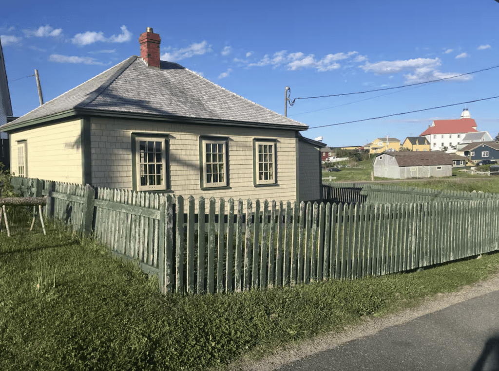 a maritime style home with cedar shingles and a green picket fence in Bonavista, Newfoundland
