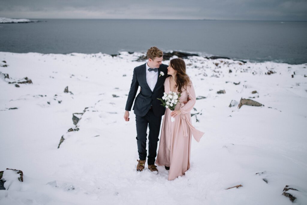 bride and groom walk through snowy landscape on Fogo Island