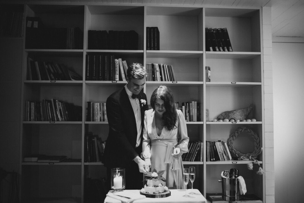 Bride and groom cut their cake in the library at the Fogo Island Inn