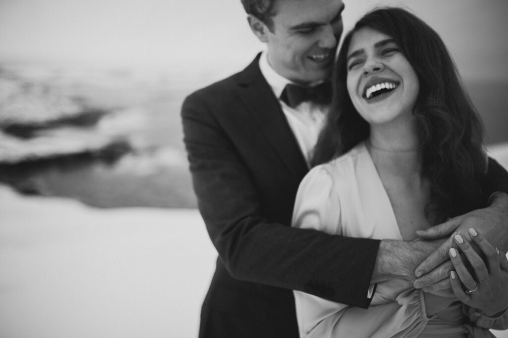 bride and groom laugh in a snowy landscape at the Fogo Island elopement