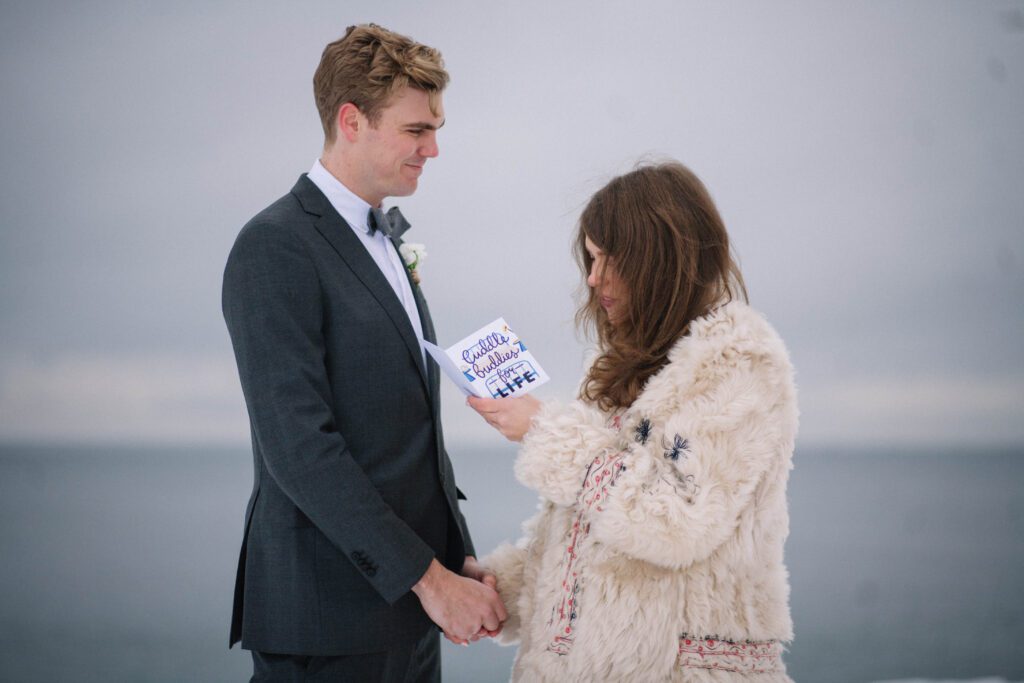 bride read's vows from a card that says "cuddle buddies for life"