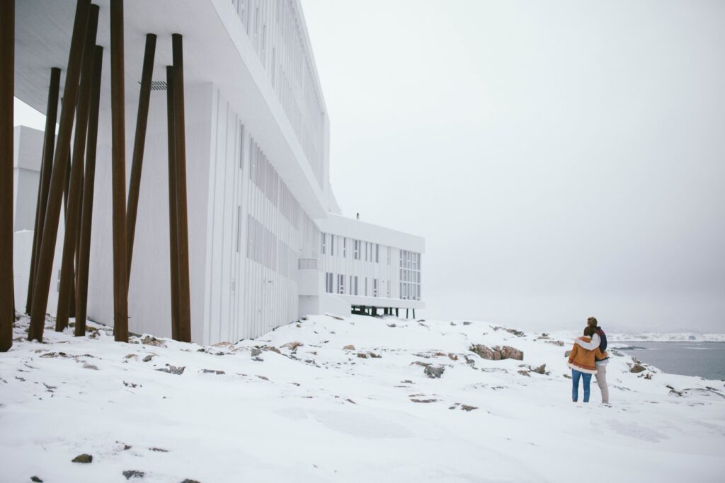 Bride and groom hold each other outside the Fogo Island Inn