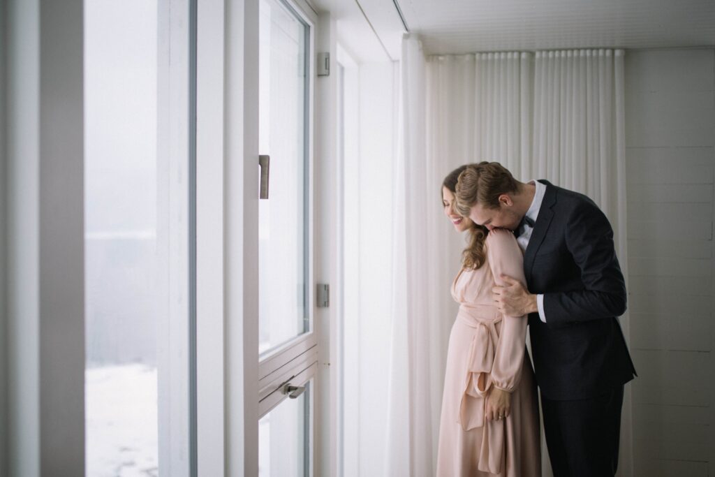 Groom kisses bride's shoulder inside the Fogo Island Inn