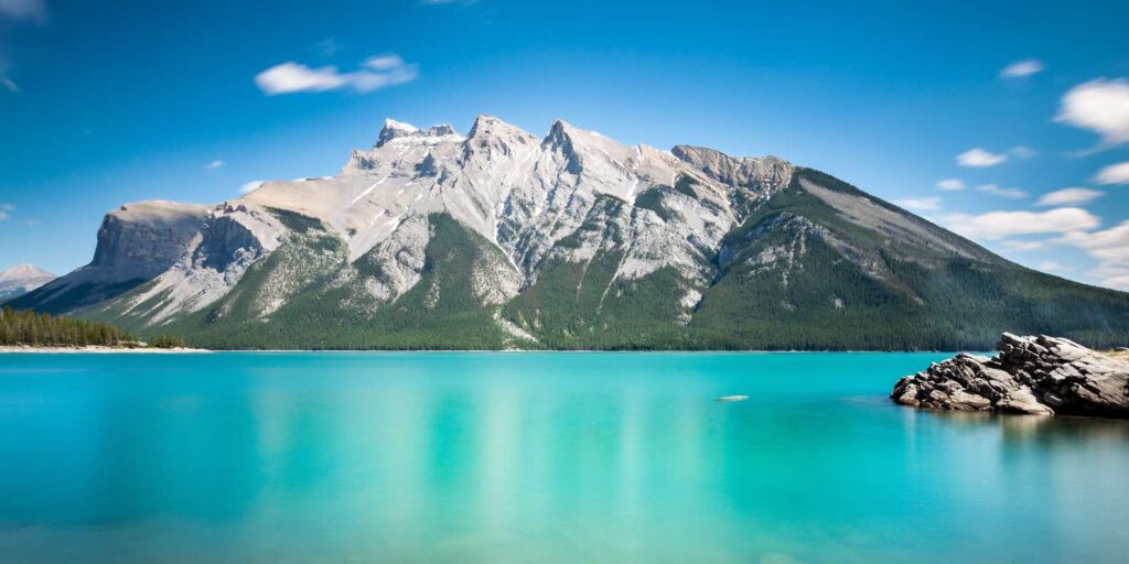 Lake Minnewanka in Banff National Park, a glacier blue lake with mountains in the background