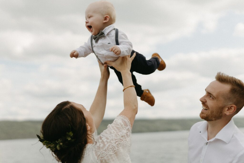 bride and groom play with baby during Newfoundland elopement