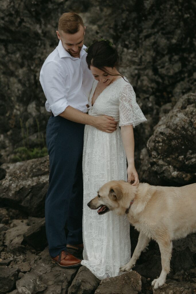 bride pets dog during Newfoundland elopement on the beach