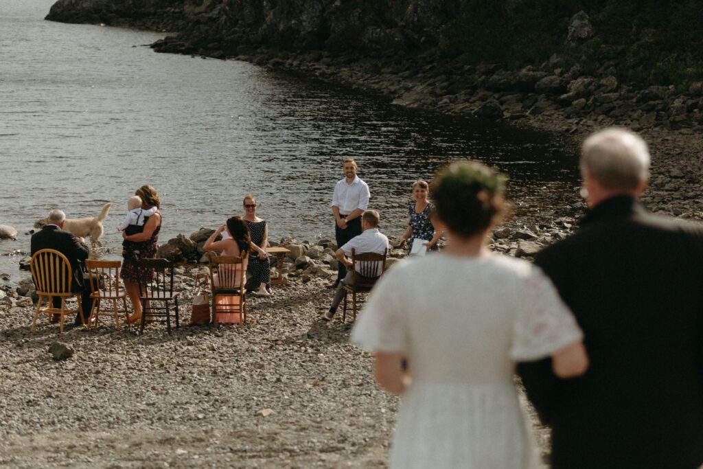 bride and father approach small elopement ceremony on the beach