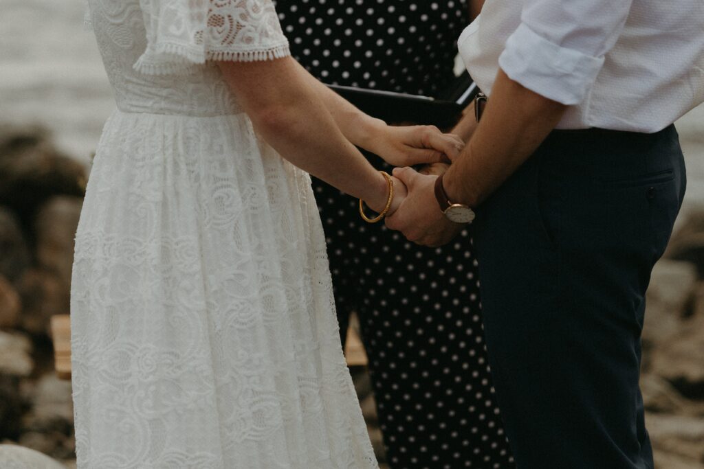 bride and groom hold hands during elopement ceremony