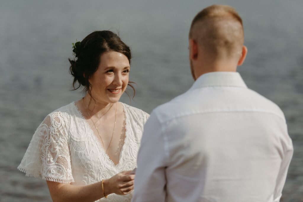 bride grins as she reads vows during elopement ceremony in Newfoundland