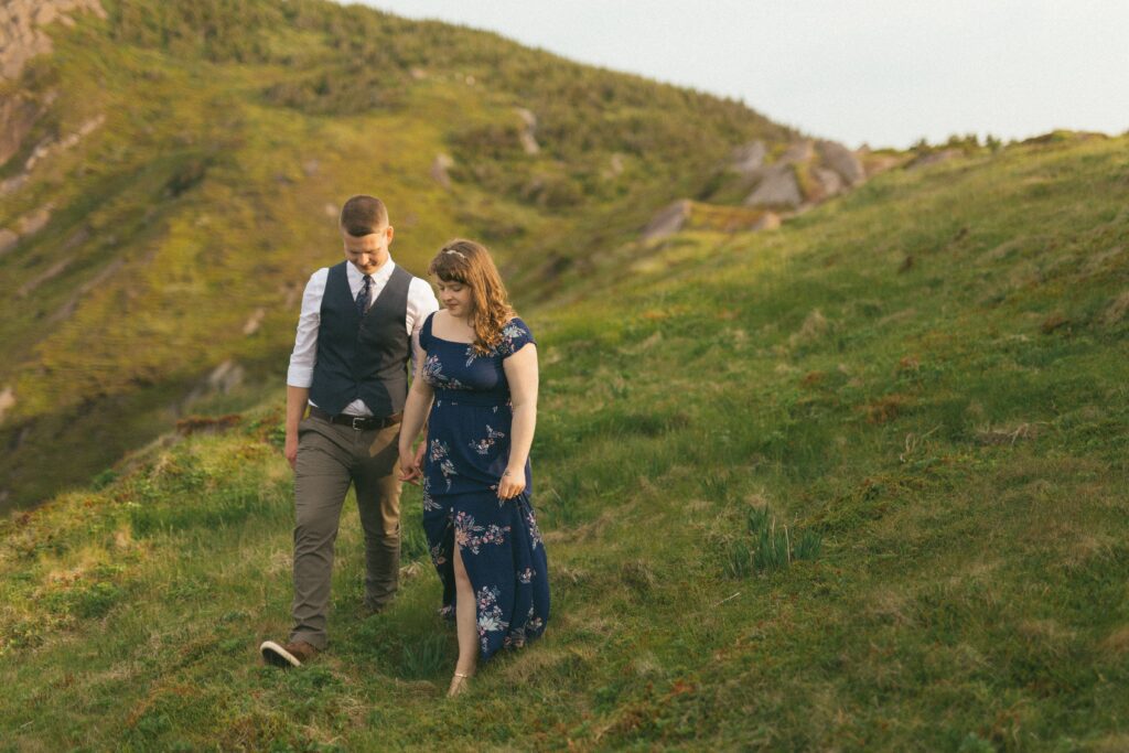 bride in blue dress and groom explore hiking trail during their Newfoundland elopement