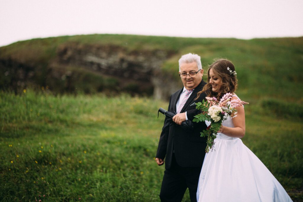 bride smiles with a bouquet of wildflowers at Newfoundland elopement
