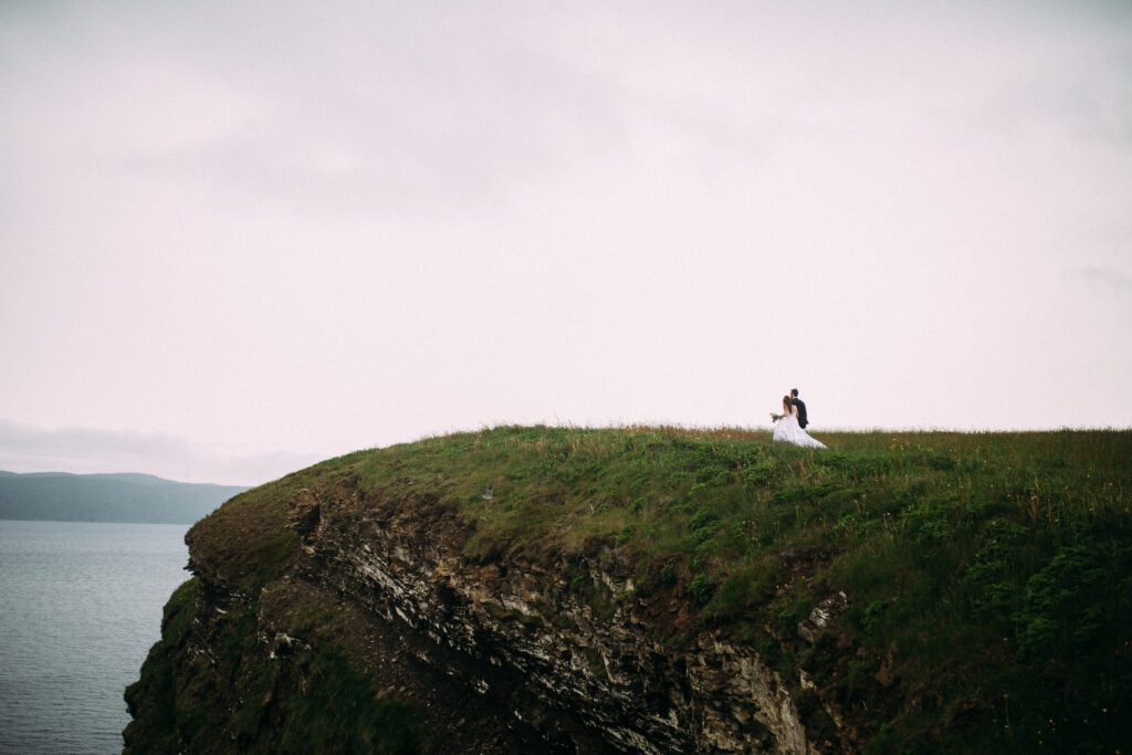 bride and groom explore the cliffs of Newfoundland during their elopement