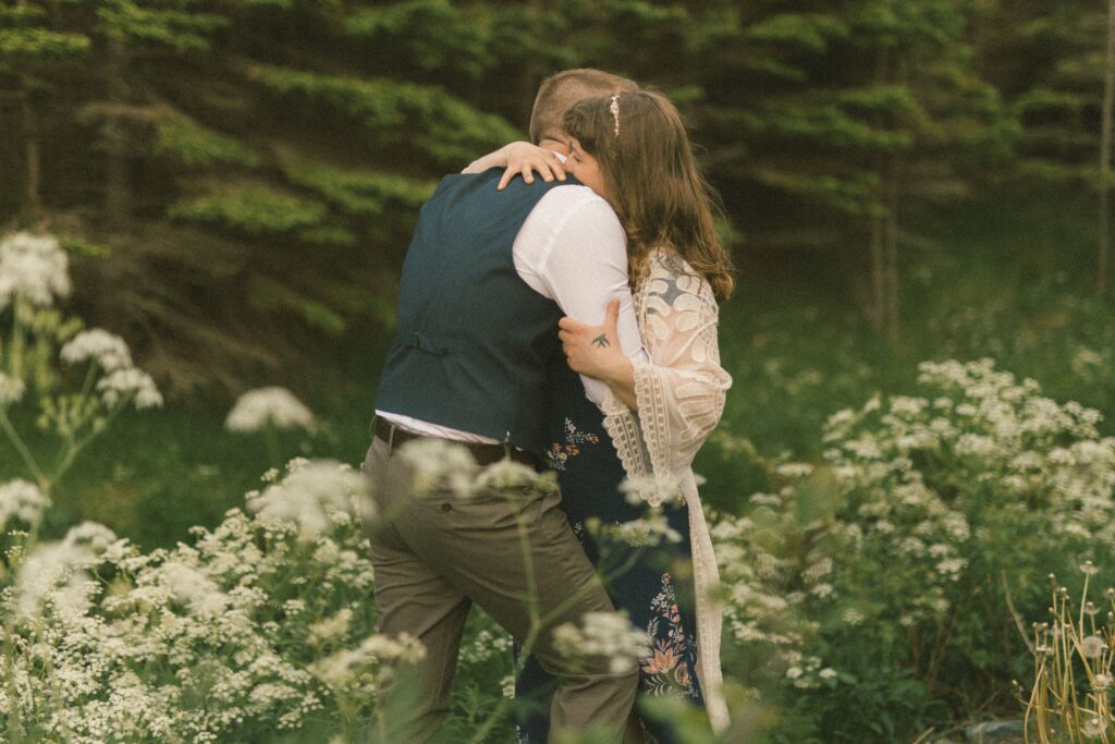 bride and groom embrace in the wildflowers during Newfoundland elopement