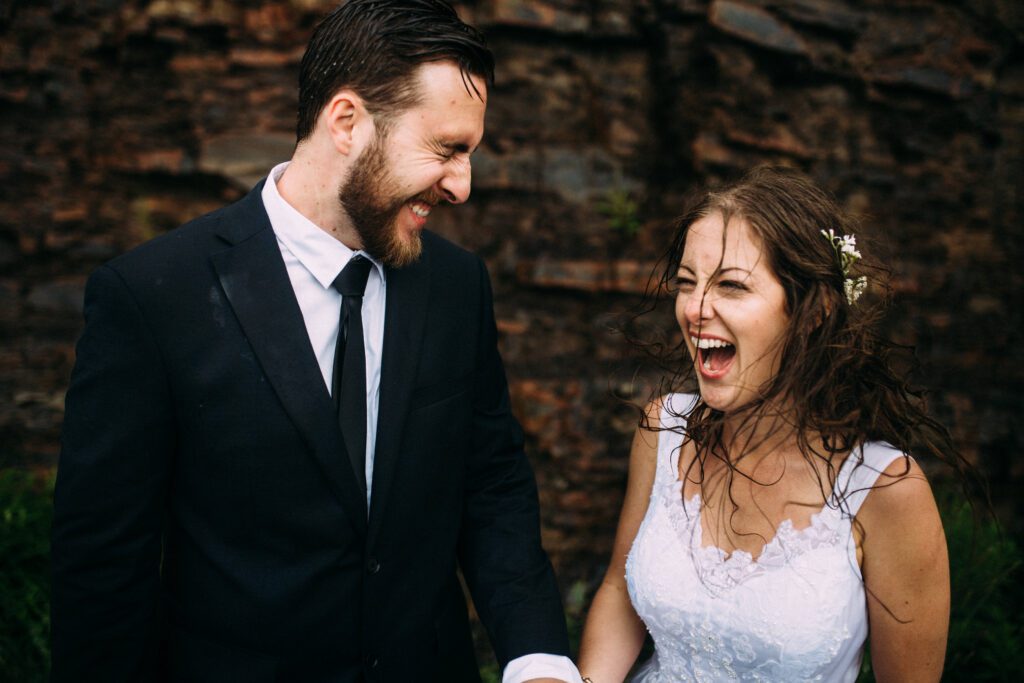 bride and groom laugh in the rain during their Newfoundland elopement