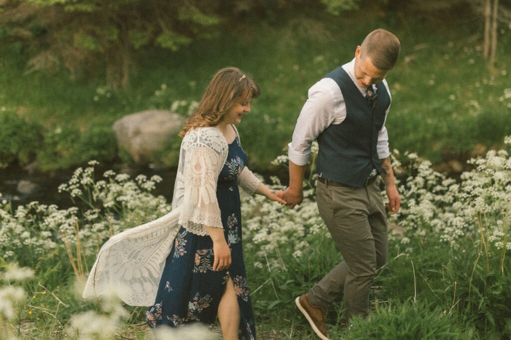 bride and groom wander through a field of wildflowers during Newfoundland elopement