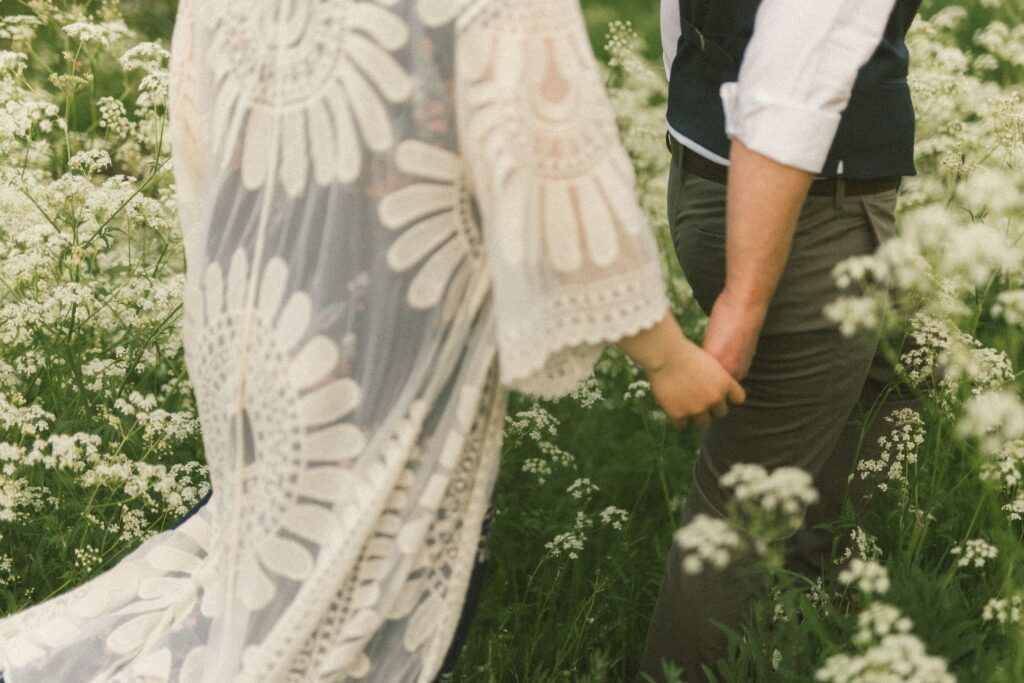bride and groom explore wildflower meadow on their elopement day