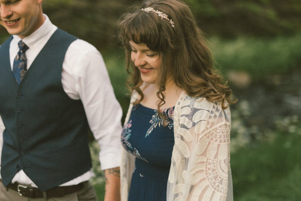 bride and groom laugh in a field of wildflowers
