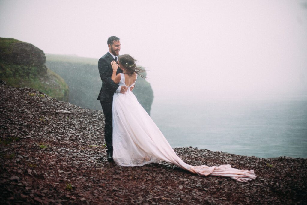 bride and groom shake the rain from their hair during rainy elopement