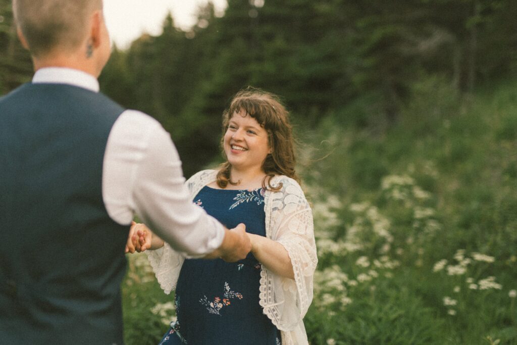 bride and groom twirl in a field of wildflowers