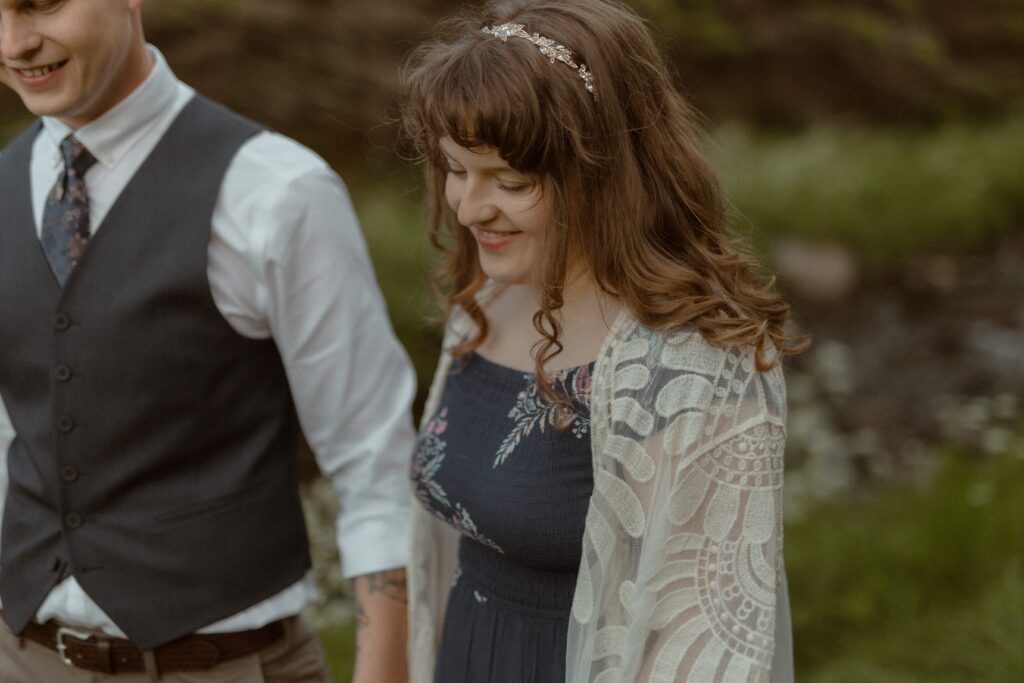 bride and groom laugh in a field of wildflowers