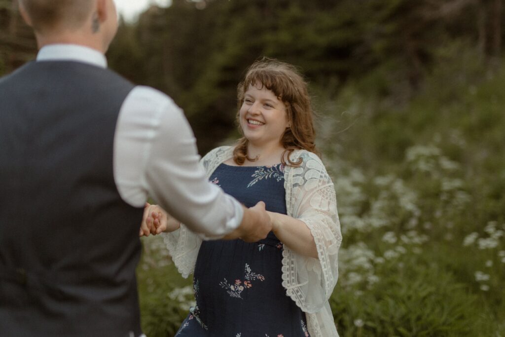 bride and groom twirl in a field of wildflowers
