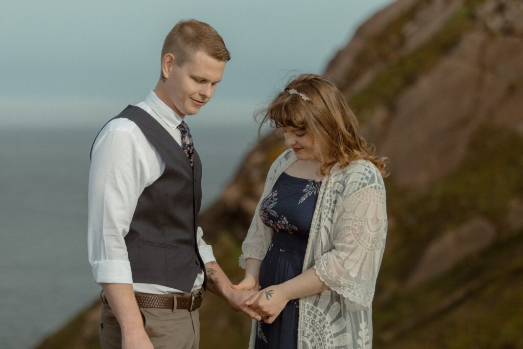 bride holds groom's hand during hiking elopement ceremony