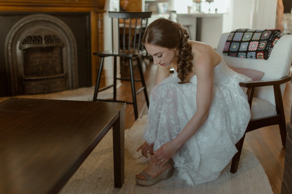 bride puts on her shoes as she gets ready for her Newfoundland elopement