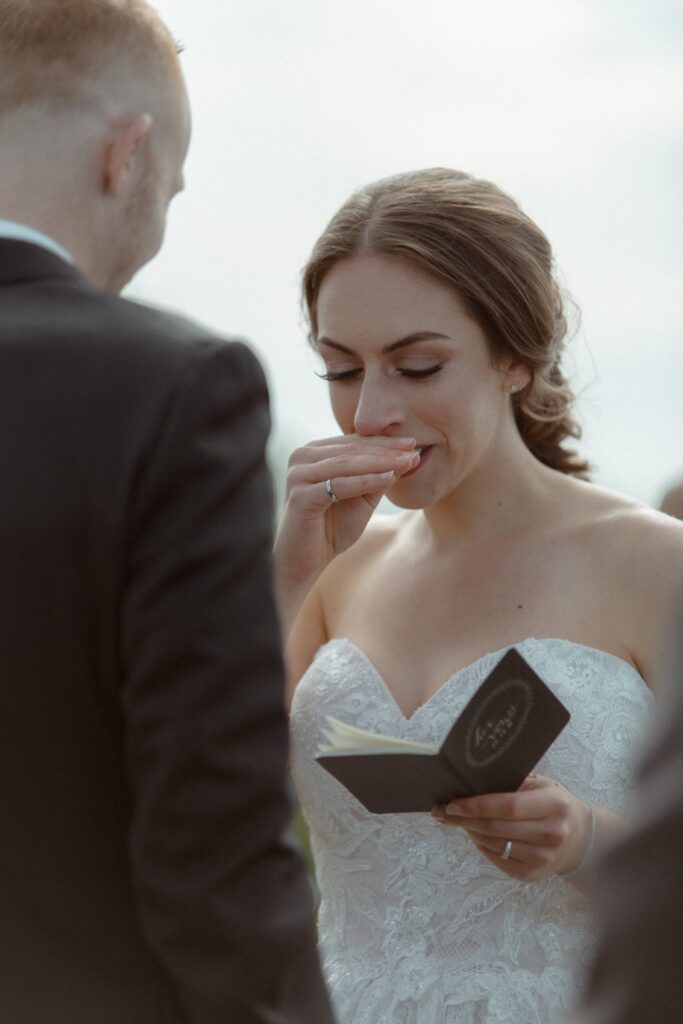 bride wipes her nose as she reads her vows during Newfoundland elopement ceremony