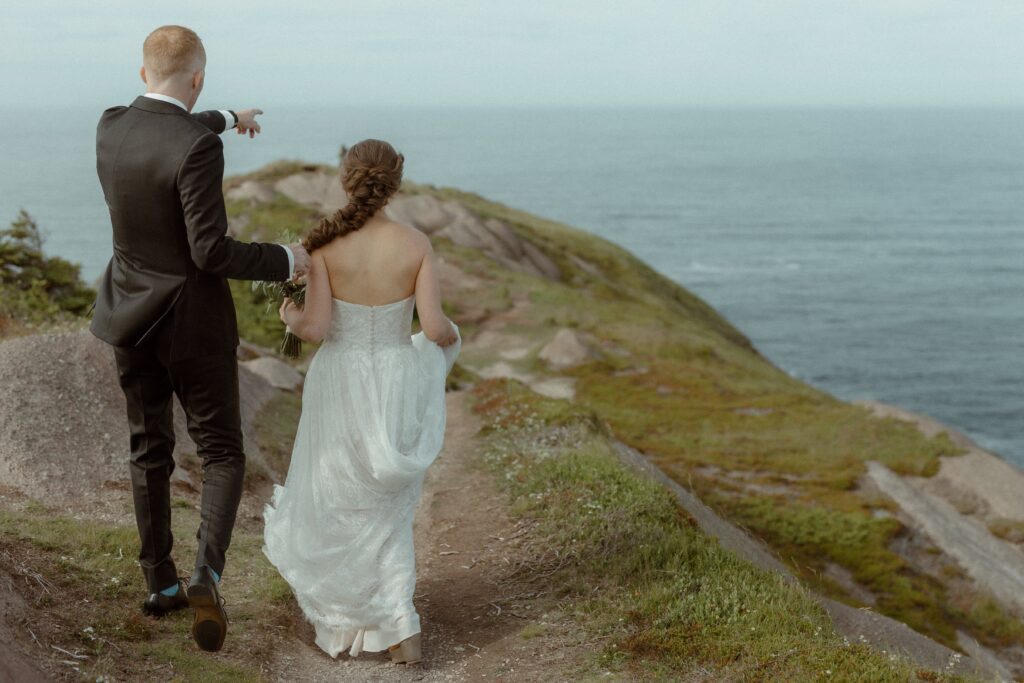 bride and groom explore the cliffs of Newfoundland together during their elopement