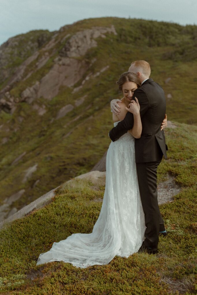 bride and groom hold each other on a cliff during their Newfoundland elopement