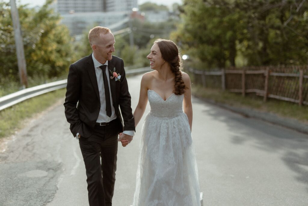 bride and groom hold hands and walk through the streets of St. John's, Newfoundland during their elopement