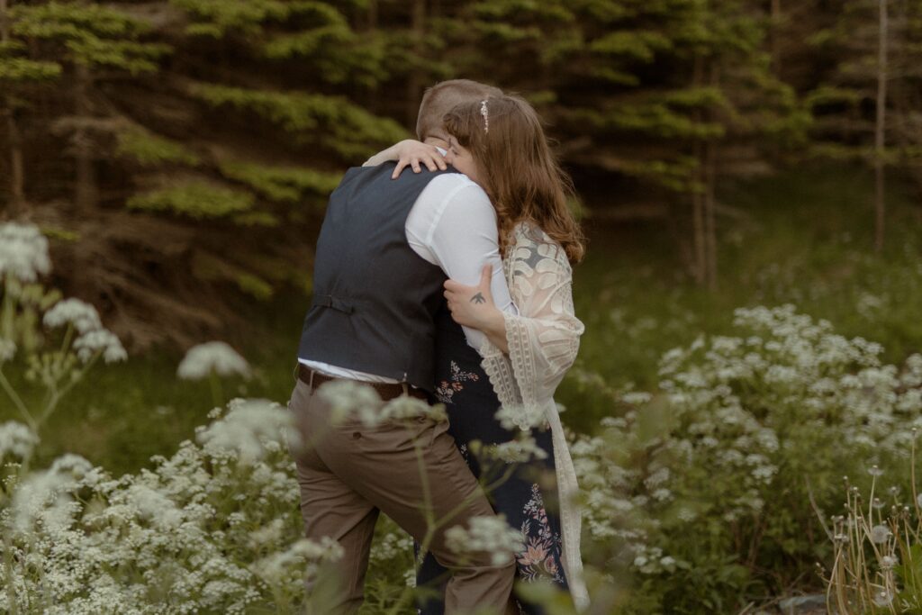 bride and groom embrace in the wildflowers during Newfoundland elopement