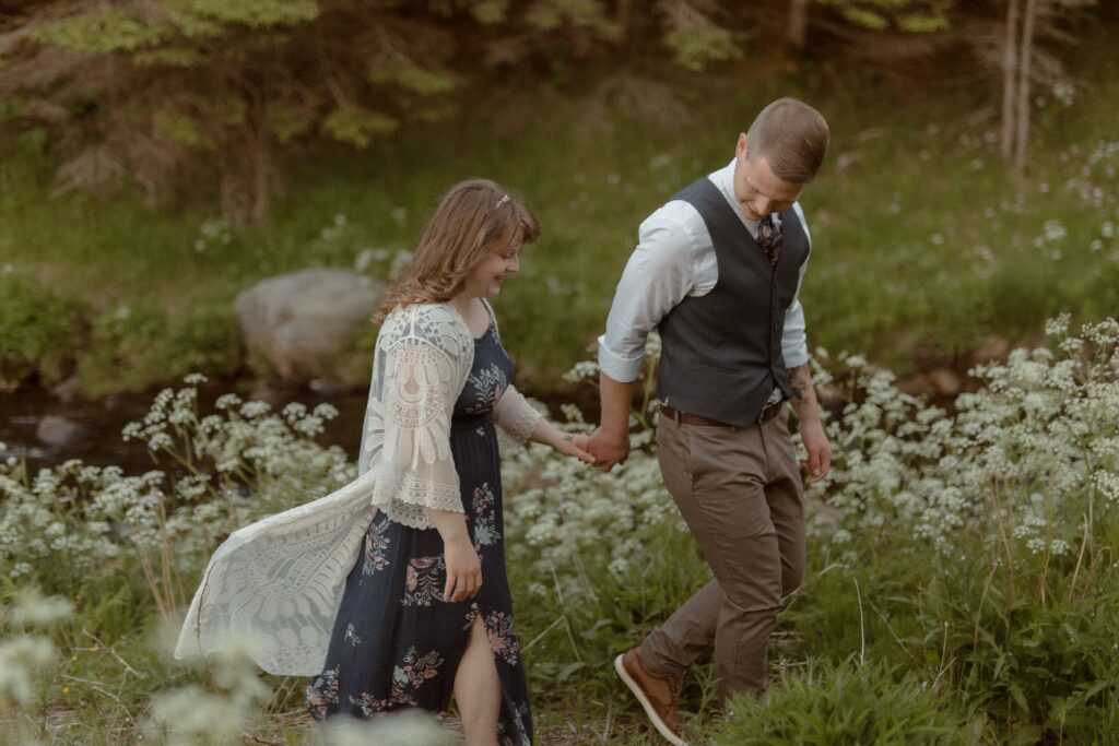 bride and groom wander through a field of wildflowers during Newfoundland elopement