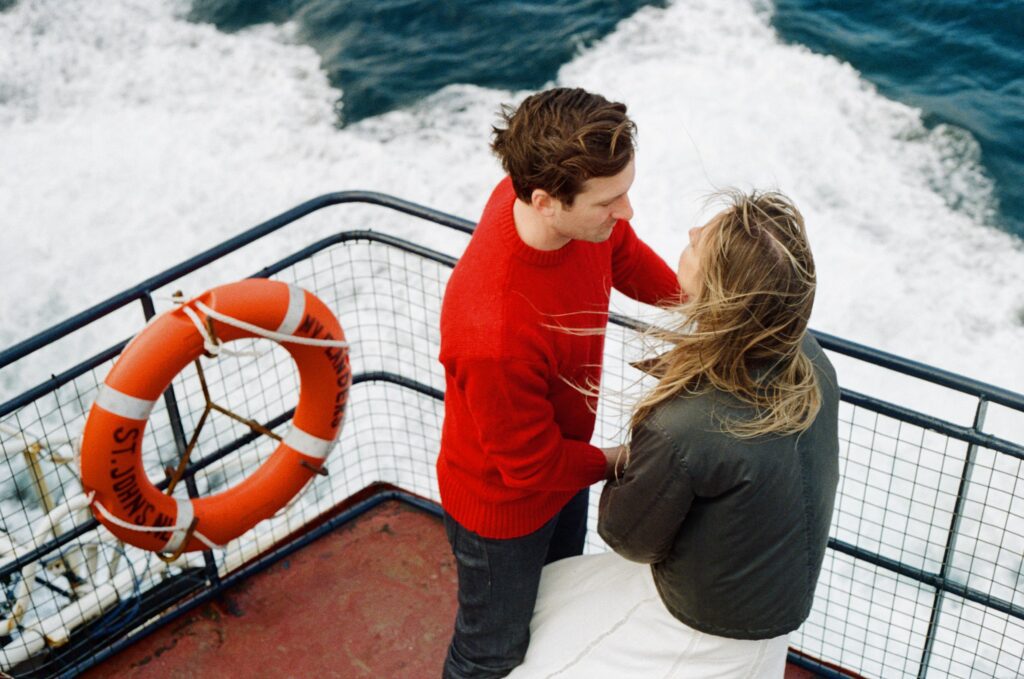 bride and groom watch the swells on Bell Island Ferry deck during elopement
