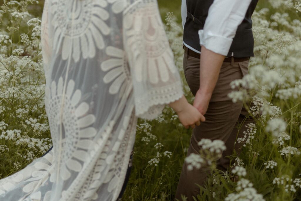 bride and groom explore wildflower meadow on their elopement day