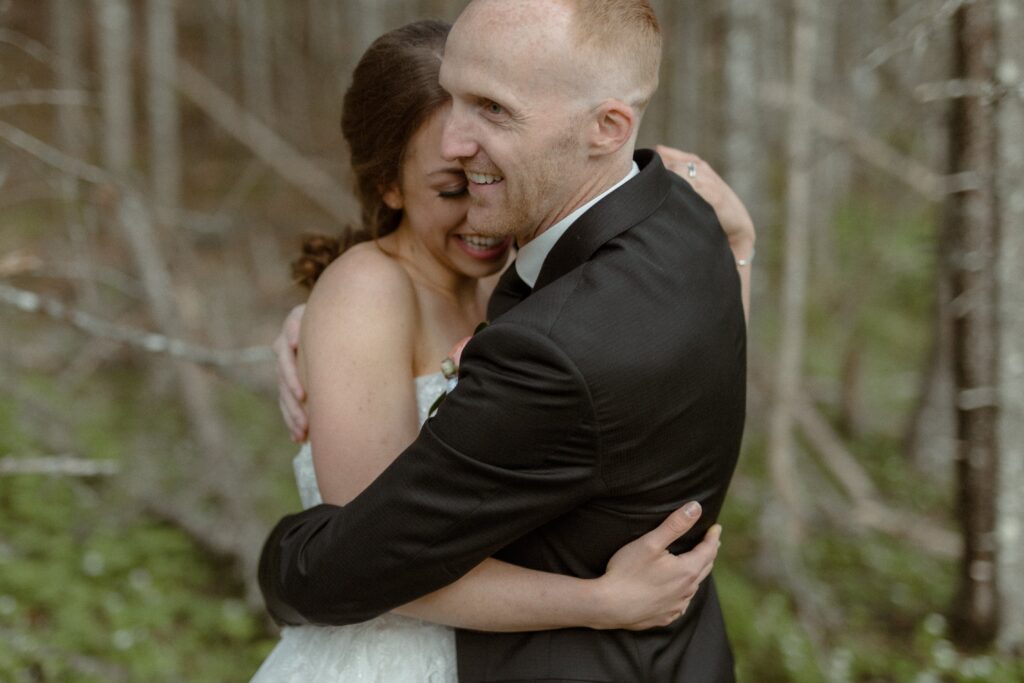 bride and groom hold each other close in the forest during Newfoundland elopement