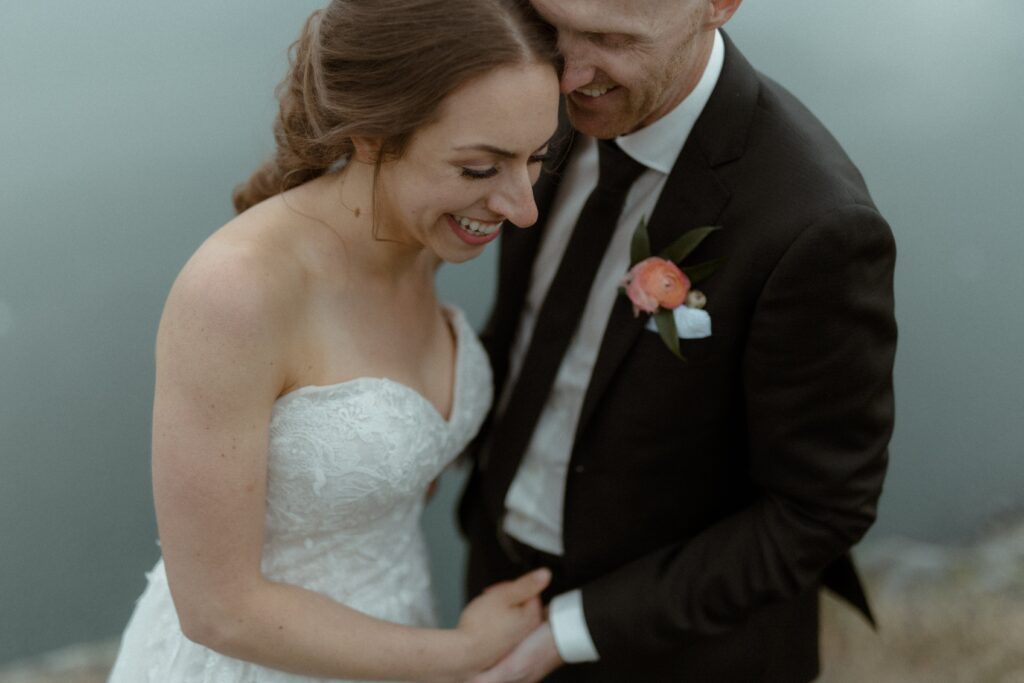 bride and groom laugh by the ocean during Newfoundland elopement