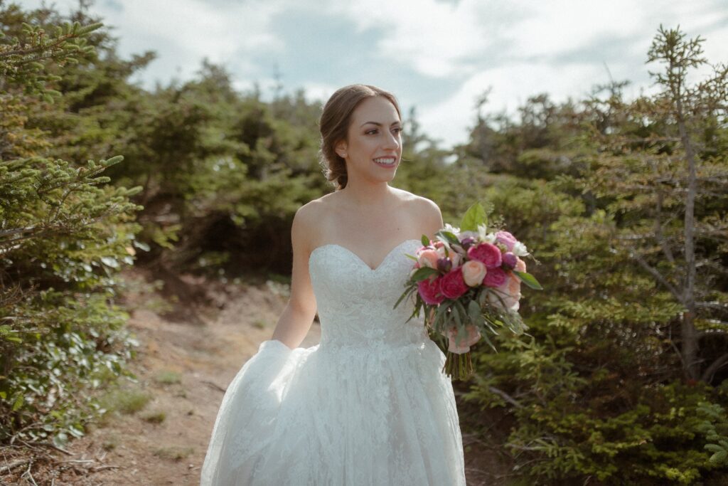 bride emerges from hiking trail to approach elopement ceremony spot