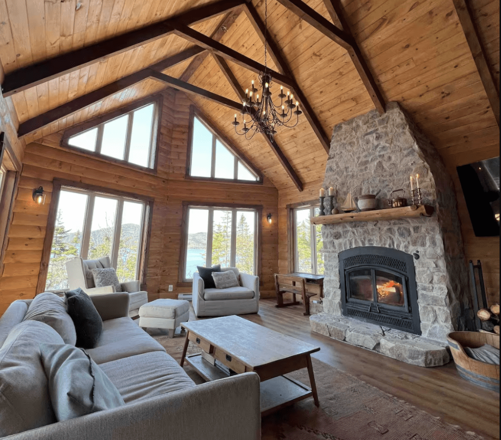 luxurious cabin interior in Newfoundland with stone fireplace and A-Frame windows