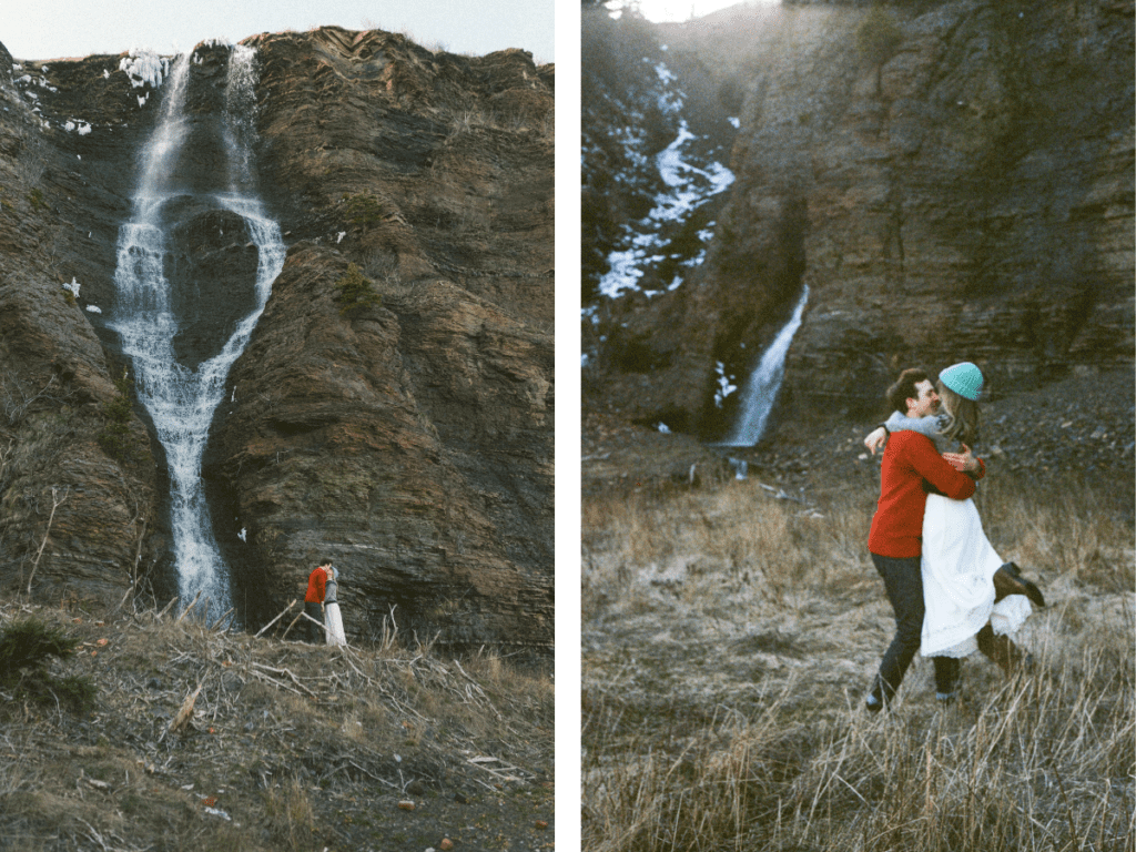 couple jump into each others arms in front of a waterfall