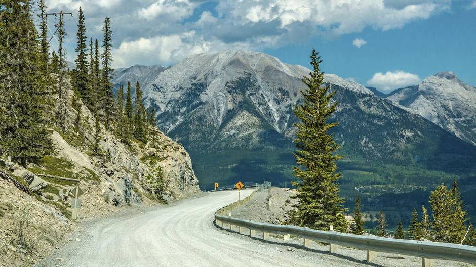 A dirt road in the foreground with mountains in the background in Kananaskis, Alberta