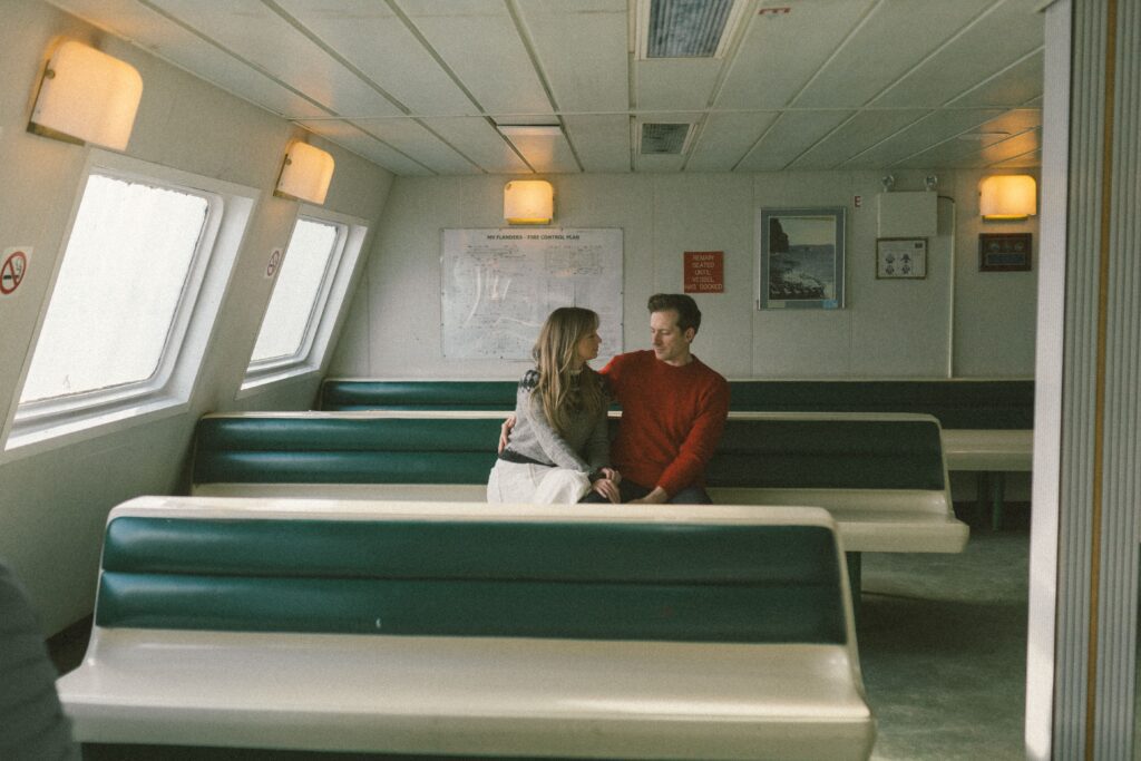 couple sit in seating area on old fashioned ferry
