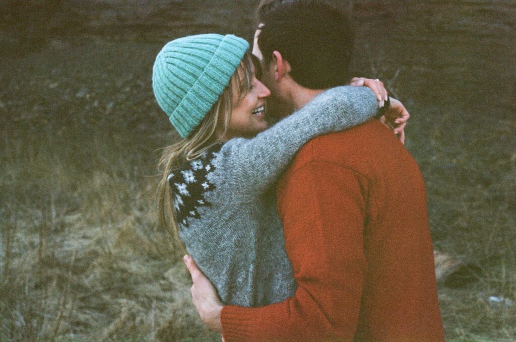 couple in wool sweaters embrace
