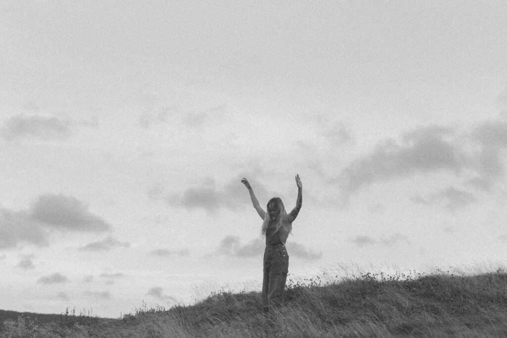 woman dances in the tall grass in Squamish, BC