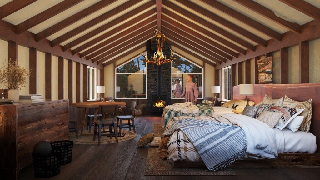 the inside of a glamping tent with two beds, a woodstove, and a pair of antlers