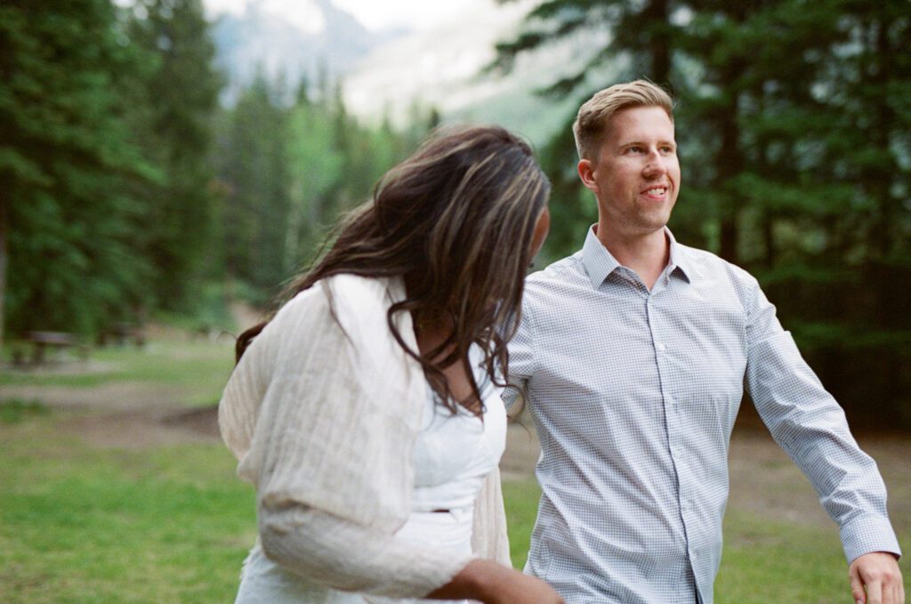 bride and groom laugh in the forest in Banff National Park