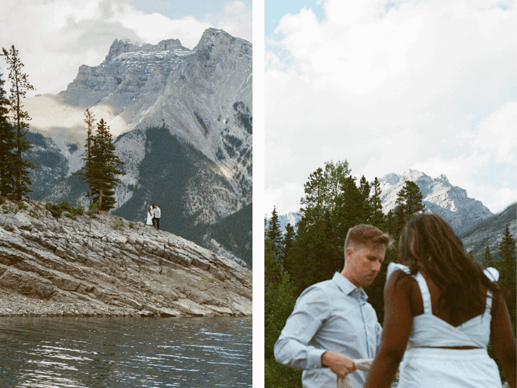 bride and groom explore a rocky outcrop in Lake Minnewanka in Banff with mountains all around them