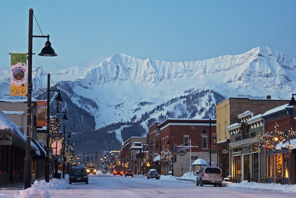 historic brick buildings in Fernie, BC at dusk with a snowy mountain in the background