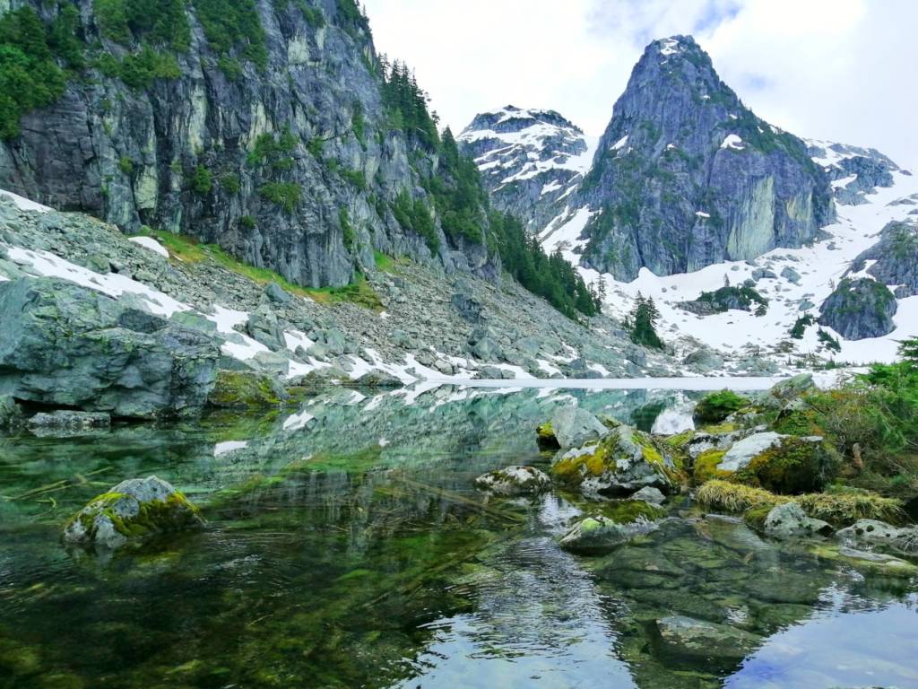 The rocky Watersprite Lake in BC in the foreground with an alpine summit in the background